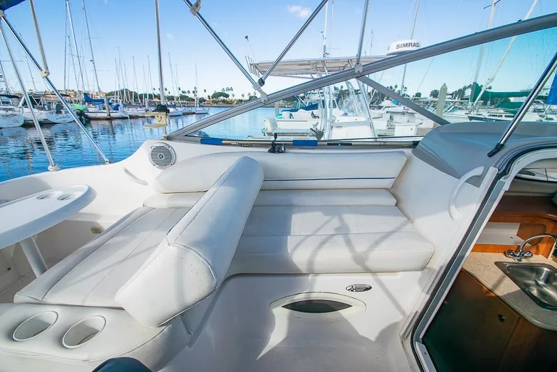 Slide: The Image of 2010 Bayliner 2450 Ciera boat interior with white seating and marina view. - 26