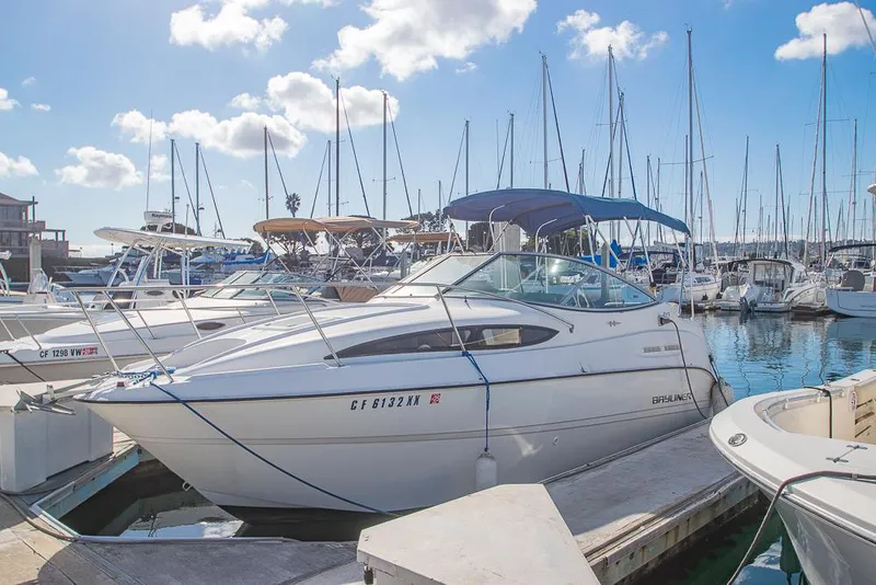 Slide: The Image of Bayliner 2450 Ciera 2010 docked at marina with sailboats in background. - 3