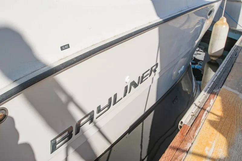 Slide: The Image of Bayliner 2450 Ciera 2010 boat docked, showing brand logo and hull details. - 4