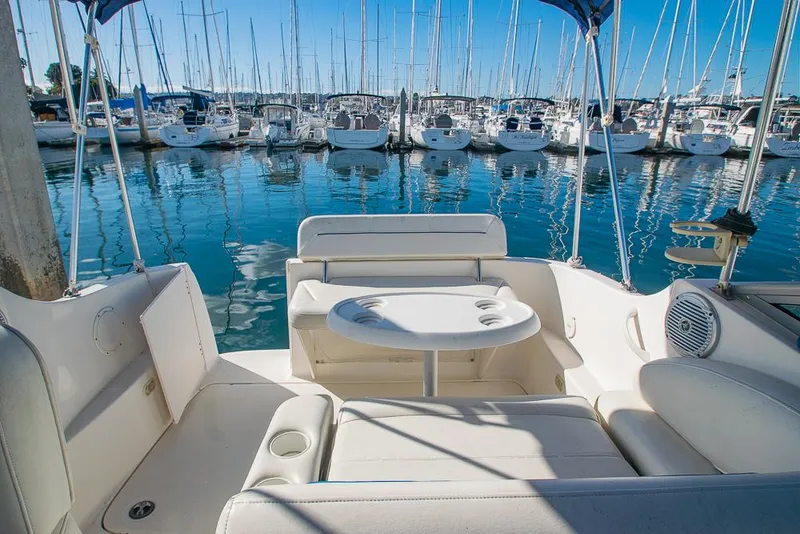 Slide: The Image of Bayliner 2450 Ciera 2010 boat interior with marina view, featuring seating and table. - 6