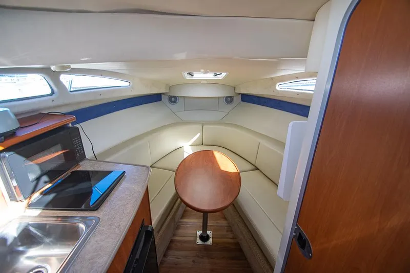 Slide: The Image of Interior of 2010 Bayliner 2450 Ciera boat with seating, table, and kitchenette. - 9