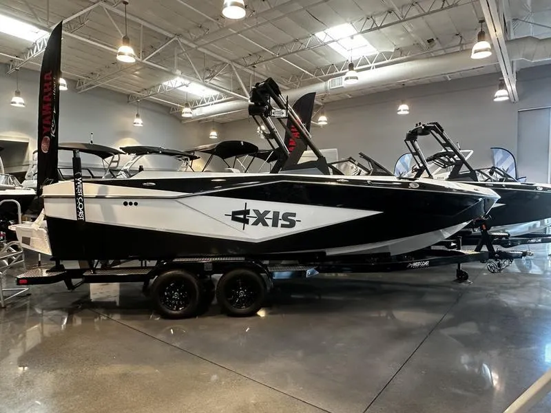 The Image of 2025 Axis T235 boat displayed in a showroom, featuring sleek black and white design. - 0