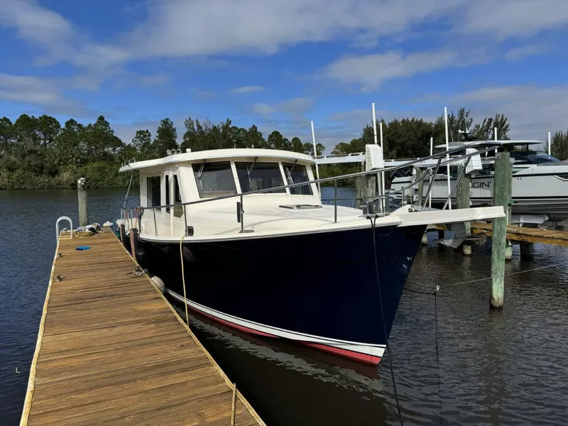Slide: The Image of 2008 Mainship 34 Trawler Hardtop docked at a marina under a blue sky. - 1