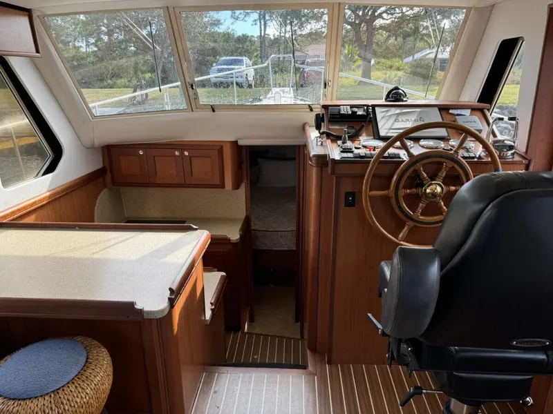 Slide: The Image of 2008 Mainship 34 Trawler Hardtop interior with helm, seating, and wood finish. - 11