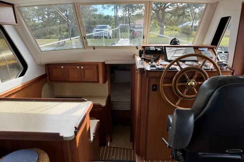 Slide: The Image of 2008 Mainship 34 Trawler Hardtop interior with helm, seating, and wood finish. - 12