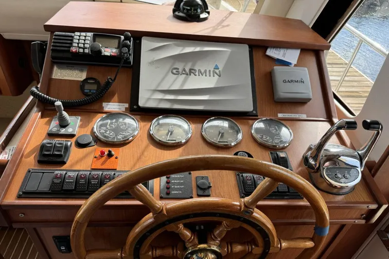 Slide: The Image of 2008 Mainship 34 Trawler Hardtop helm with Garmin navigation and classic wooden steering wheel. - 14