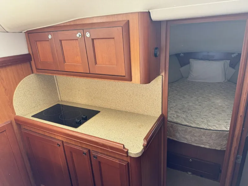 Slide: The Image of 2008 Mainship 34 Trawler Hardtop interior with kitchenette and cozy sleeping area. - 19