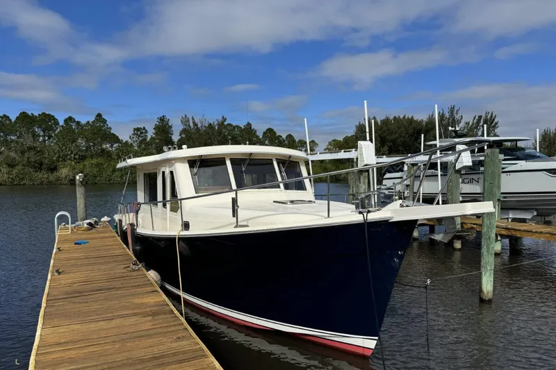 Slide: The Image of 2008 Mainship 34 Trawler Hardtop docked on a sunny day. - 2