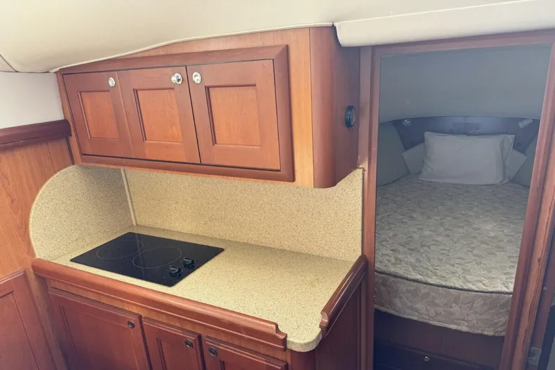 Slide: The Image of 2008 Mainship 34 Trawler Hardtop interior with kitchenette and cozy sleeping area. - 20