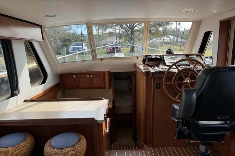Slide: The Image of 2008 Mainship 34 Trawler Hardtop interior with helm, seating, and wood finishes. - 8