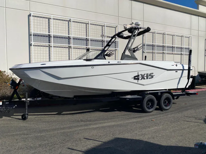 Slide: The Image of 2025 Axis T235 boat on trailer, white exterior, parked outdoors. - 1