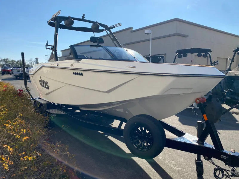 Slide: The Image of 2025 Axis T235 boat on trailer, parked outdoors in sunlight. - 5