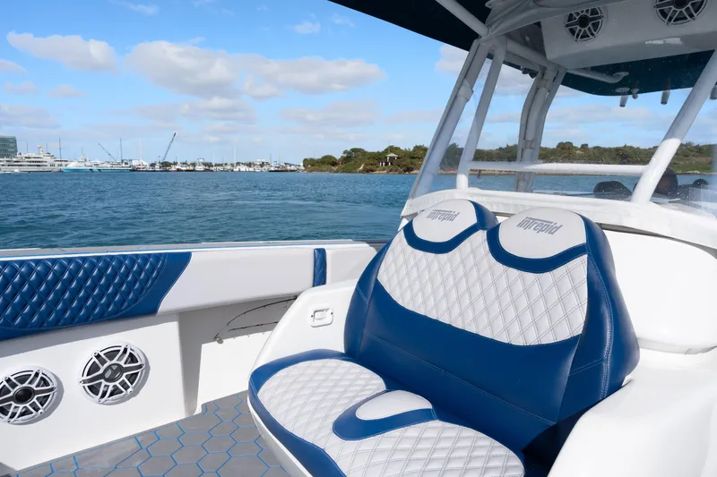 Slide: The Image of 2007 Intrepid 375 Center Console boat interior with blue and white seating, on calm water. - 13