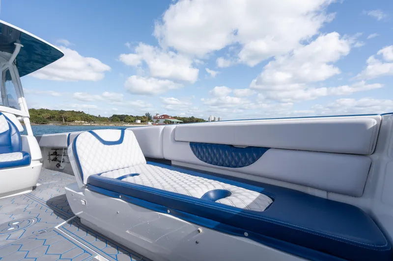 Slide: The Image of 2007 Intrepid 375 Center Console boat with blue and white seating under a cloudy sky. - 17