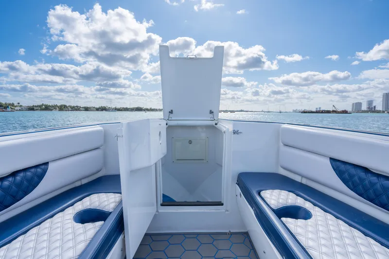 Slide: The Image of 2007 Intrepid 375 Center Console boat interior with blue and white seating, open storage compartment. - 19