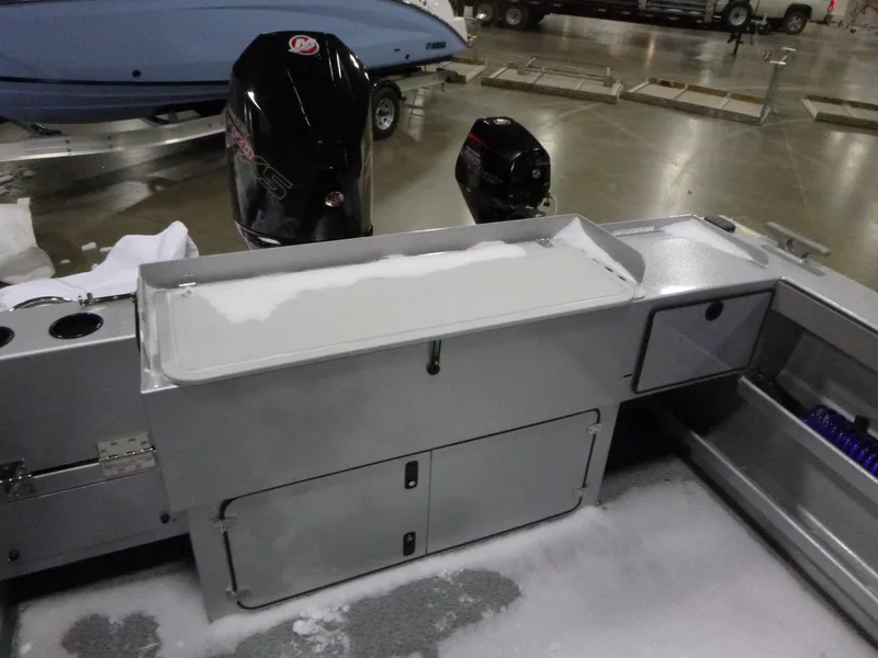 Slide: The Image of KingFisher 2425 Escape HT 2025 boat interior with storage compartments and motor, displayed indoors. - 17