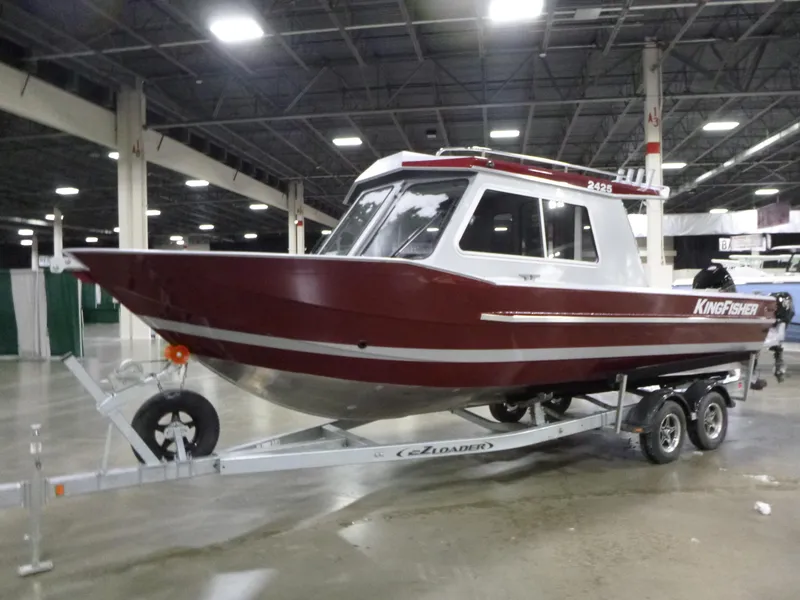 Slide: The Image of 2025 KingFisher 2425 Escape HT boat on display in an indoor showroom. - 2