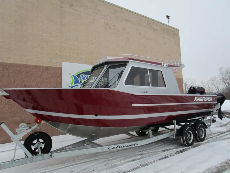 Slide: The Image of 2025 KingFisher 2425 Escape HT boat on trailer, red and silver design, parked outdoors. - 25