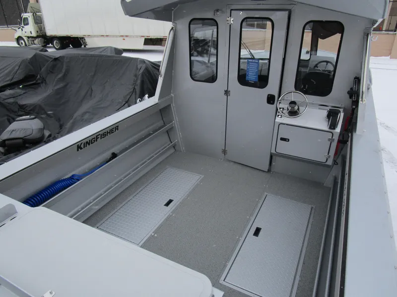 Slide: The Image of 2025 KingFisher 2425 Escape HT boat interior with steering console and storage compartments. - 30
