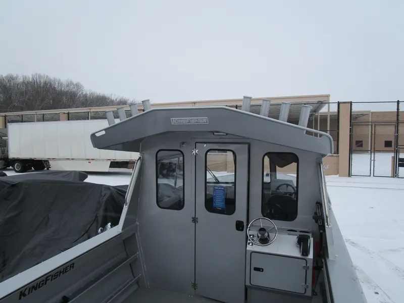 Slide: The Image of 2025 KingFisher 2425 Escape HT boat in snowy setting, showcasing cabin and helm. - 31