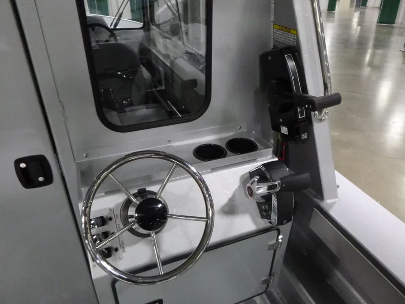 Slide: The Image of 2025 KingFisher 2425 Escape HT boat helm with steering wheel and controls. - 9