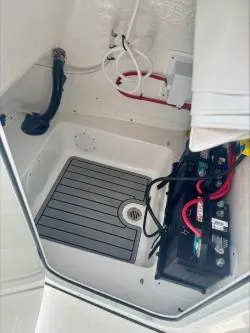 Slide: The Image of 2025 Tidewater 210 LXF boat battery compartment with wiring and drainage system. - 12