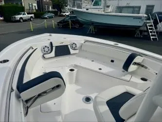 Slide: The Image of 2025 Tidewater 210 LXF boat interior with seating and speakers in a marina setting. - 6