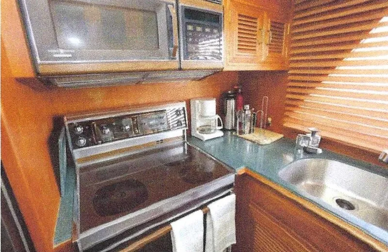 Slide: The Image of 1984 Ocean Alexander yacht kitchen with stove, microwave, and sink. - 15