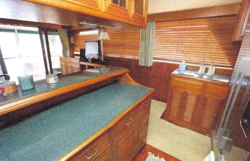 Slide: The Image of 1984 Ocean Alexander Flying Bridge Motor Yacht interior with wood cabinetry and green countertops. - 16