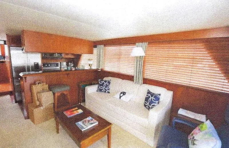 Slide: The Image of 1984 Ocean Alexander Flying Bridge Motor Yacht interior with sofa, wooden accents, and cozy decor. - 25