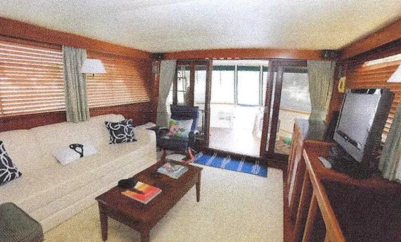 Slide: The Image of Interior of 1984 Ocean Alexander Flying Bridge Motor Yacht, featuring cozy seating and wooden accents. - 26