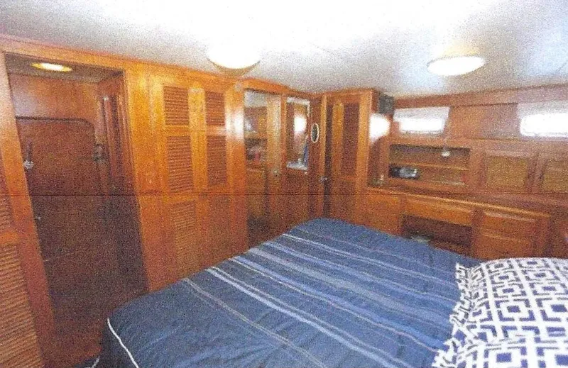 Slide: The Image of 1984 Ocean Alexander Flying Bridge Motor Yacht cabin with wooden interior and cozy bed. - 29