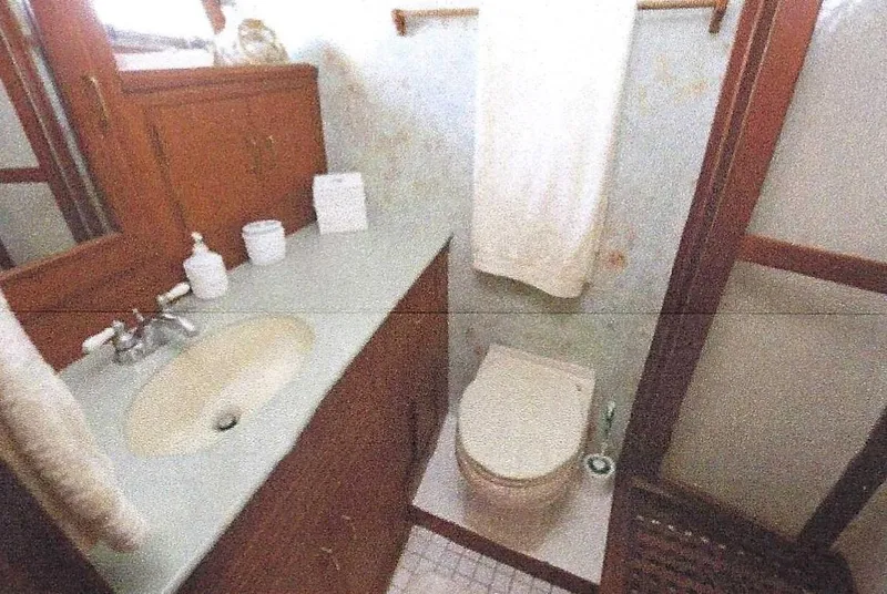Slide: The Image of 1984 Ocean Alexander Flying Bridge Motor Yacht bathroom with sink, toilet, and wooden cabinetry. - 30
