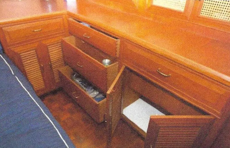 Slide: The Image of 1984 Ocean Alexander Flying Bridge Motor Yacht interior with wooden cabinetry and storage drawers. - 31