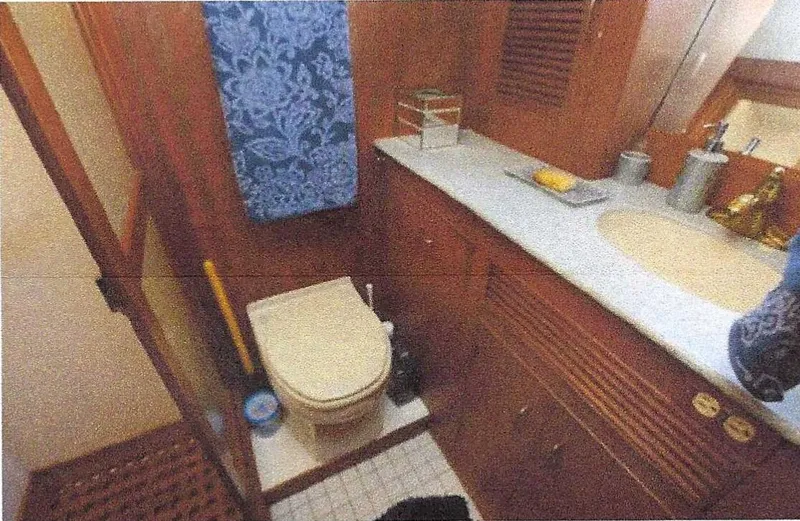 Slide: The Image of 1984 Ocean Alexander Flying Bridge Motor Yacht bathroom with wooden cabinetry and blue towel. - 33