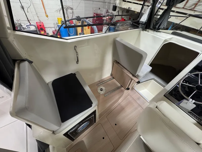 Slide: The Image of 2025 Trophy 25 Pilothouse interior with seating and steering wheel, showcasing modern design. - 11