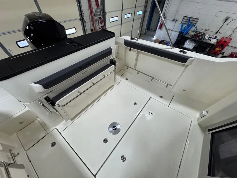 Slide: The Image of 2025 Trophy 25 Pilothouse boat interior, featuring spacious deck and seating in a garage setting. - 4