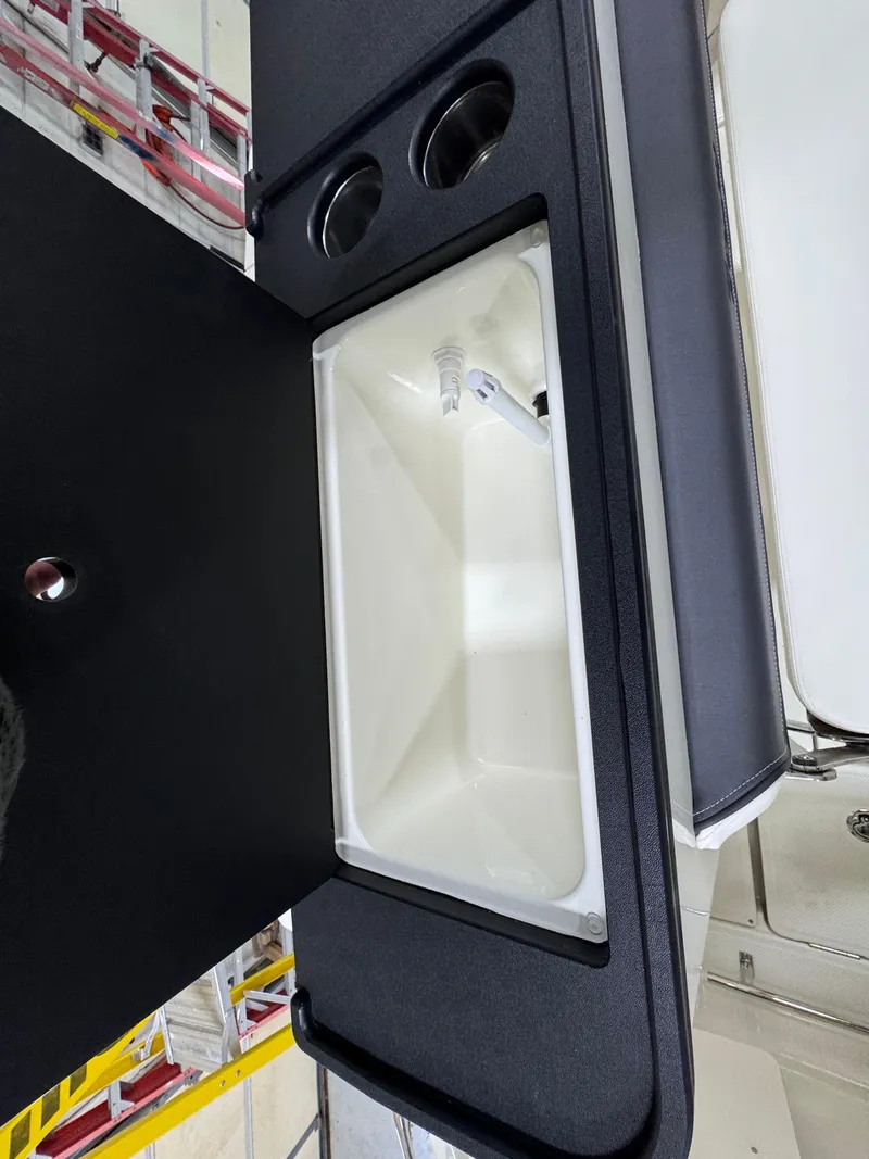 Slide: The Image of 2025 Trophy 25 Pilothouse interior sink and cup holders. - 6