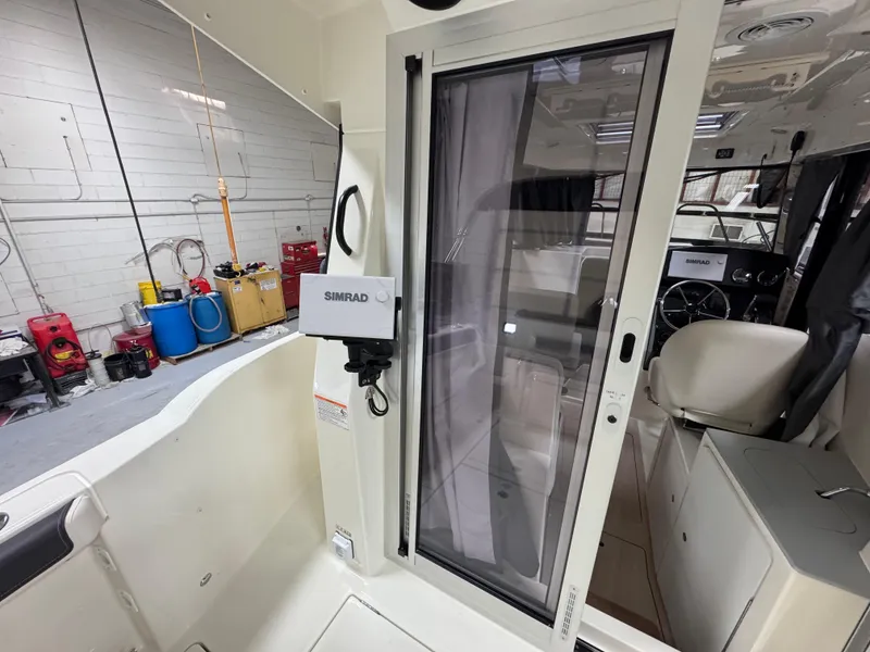 Slide: The Image of Interior view of 2025 Trophy 25 Pilothouse boat, featuring modern controls and seating. - 7