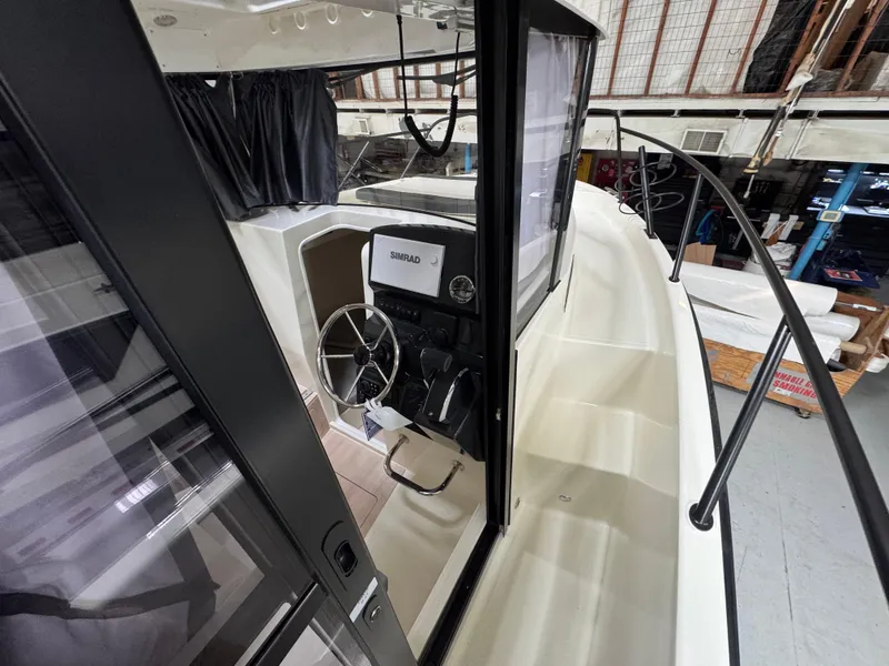 Slide: The Image of 2025 Trophy 25 Pilothouse boat interior with steering wheel and navigation equipment. - 8