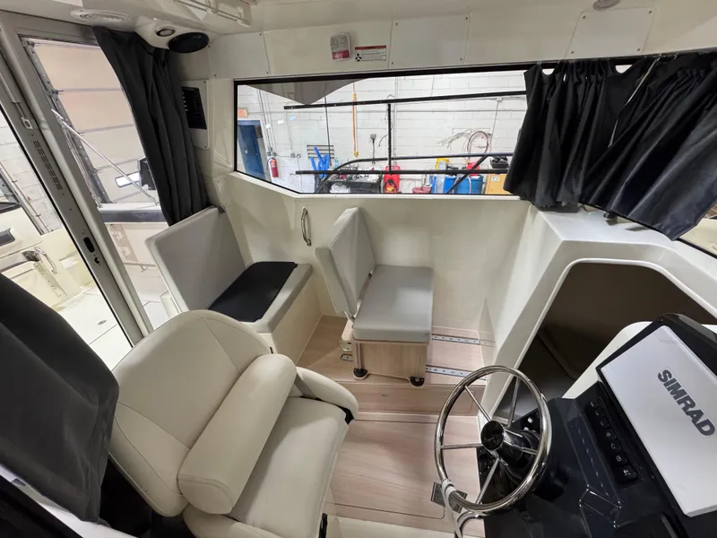 Slide: The Image of Interior of 2025 Trophy 25 Pilothouse boat with seating and steering wheel. - 9