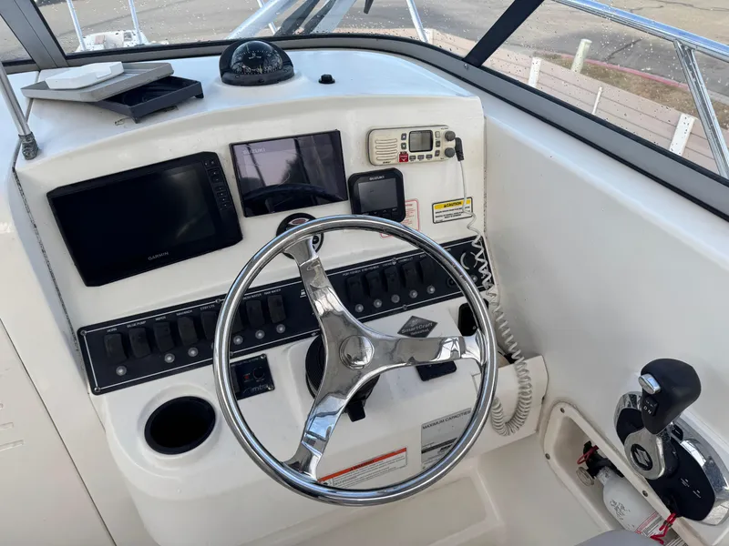 Slide: The Image of 2006 Boston Whaler 235 Conquest helm with steering wheel, navigation screens, and controls. - 14