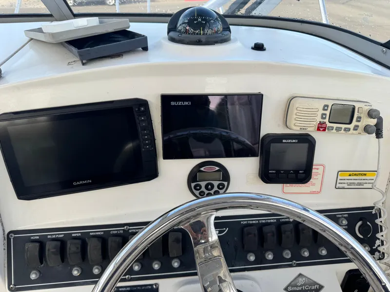 Slide: The Image of 2006 Boston Whaler 235 Conquest dashboard with Garmin and Suzuki electronics. - 15