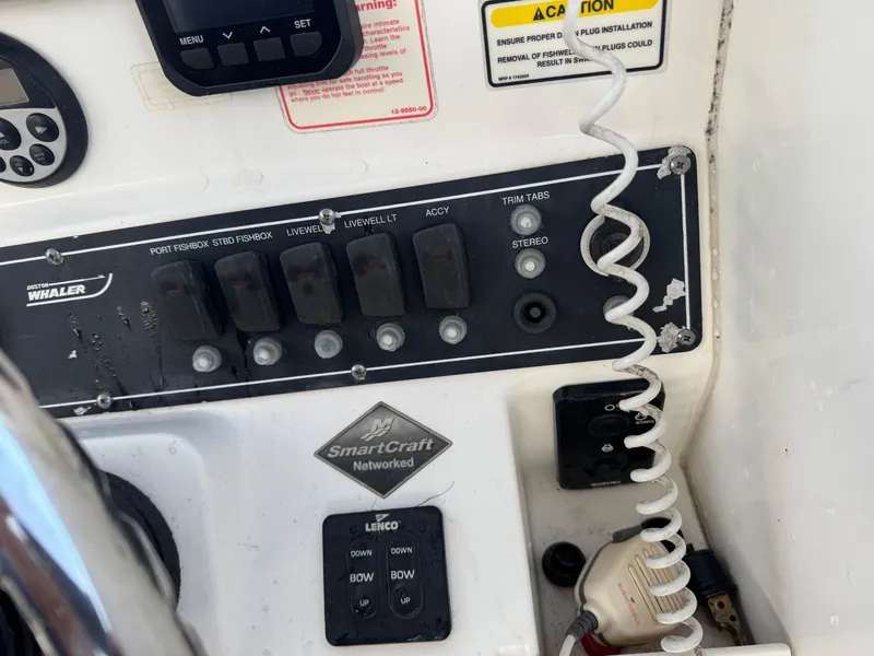 Slide: The Image of Control panel of a 2006 Boston Whaler 235 Conquest boat with various switches and SmartCraft network. - 16