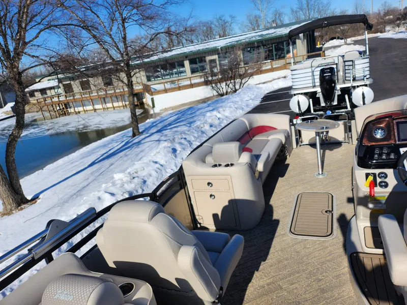 Slide: The Image of 2022 JC Neptoon 25 TT DSL pontoon boat on snowy lakeside, showcasing seating and controls. - 18