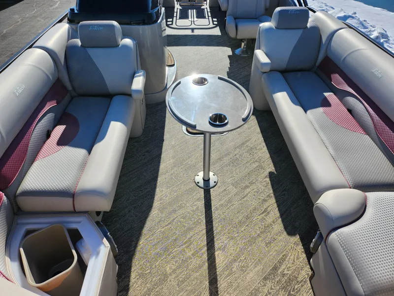 Slide: The Image of 2022 JC Neptoon 25 TT DSL pontoon boat interior with plush seating and central table. - 9