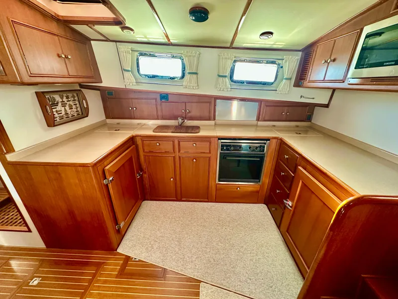 Slide: The Image of 2001 Grand Banks 49 Eastbay HX yacht kitchen with wooden cabinetry and modern appliances. - 20