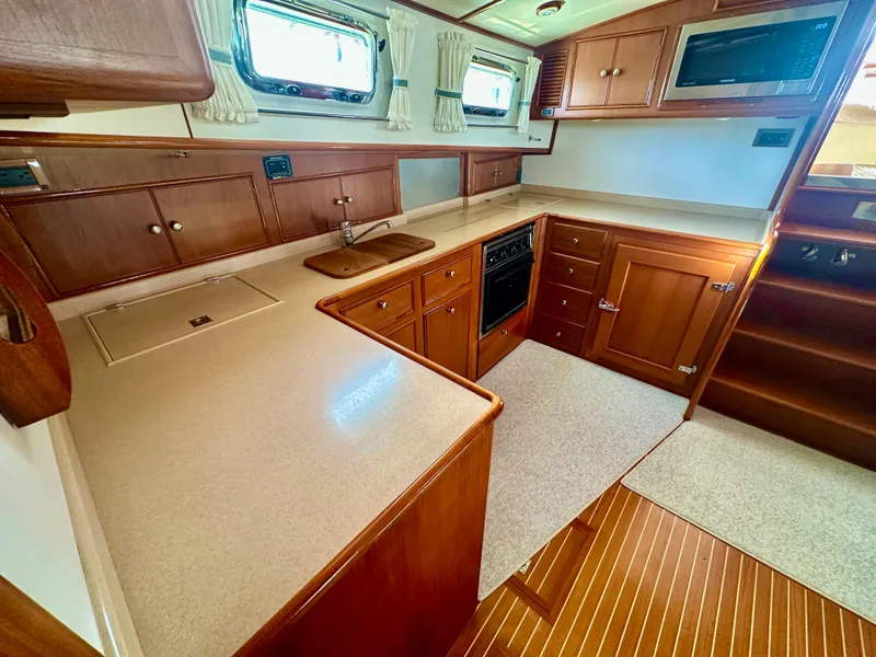 Slide: The Image of 2001 Grand Banks 49 Eastbay HX yacht kitchen with wood cabinetry and modern appliances. - 21