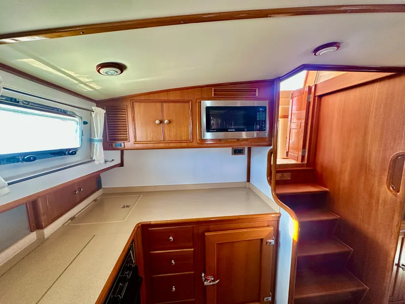 Slide: The Image of 2001 Grand Banks 49 Eastbay HX yacht interior kitchen with wood cabinetry and microwave. - 22