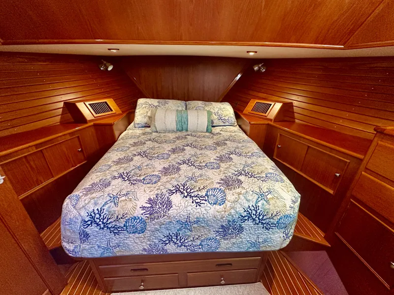 Slide: The Image of Luxurious cabin interior of 2001 Grand Banks 49 Eastbay HX with wood paneling and patterned bedding. - 27